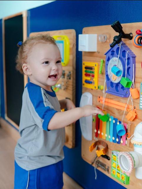 Bebê brincando com painel sensorial