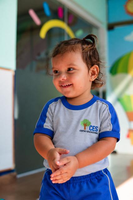 Criança pequena sorrindo com uniforme do CES