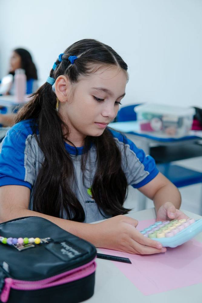 Aluna do CES usando uma calculadora em atividade de matemática